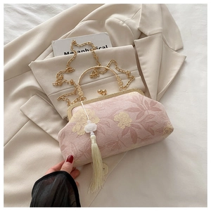 Dettaglio borsa da sera jacquard floreale rosa con cornice dorata e nappa bianca