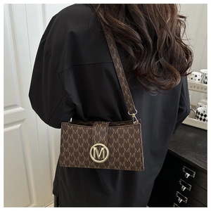 Detail of vintage brown shoulder bag with M-pattern print and gold metallic buckle
