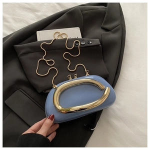Détail macro d'un sac géométrique bleu clair avec grande poignée sculpturale en métal doré