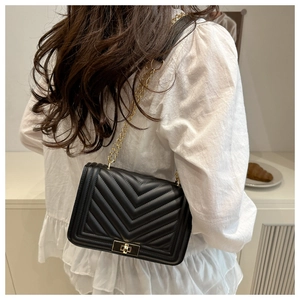 Détail du sac à bandoulière noir à surpiqûres en V avec chaîne dorée et fermoir