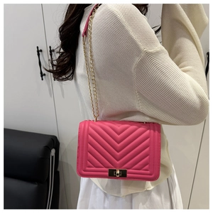 Détail du sac bandoulière matelassé rose fuchsia avec chaîne dorée et fermoir rotatif