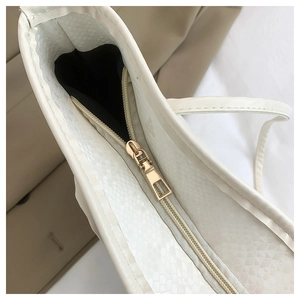 Dettaglio della borsa beige in ecopelle con cerniera dorata e trama a serpente di tendenza