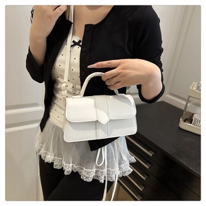 Detail of white synthetic leather crossbody bag with top handle and fine stitching