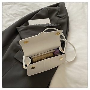 Interior view of the white flap bag showing the storage capacity and magnetic closure