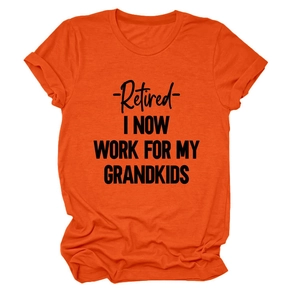 Detail of a bright orange T-shirt with black Retired I Now Work For My Grandkids text