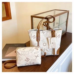 Close-up of elegant cream tote bag with tan trim and vintage letter monogram pattern