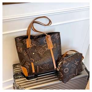 Two-piece tote bag set with monogram print on a silver suitcase, including a matching pouch