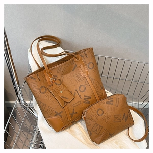 Detail of brown faux leather tote set with geometric monogram print and small matching pouch
