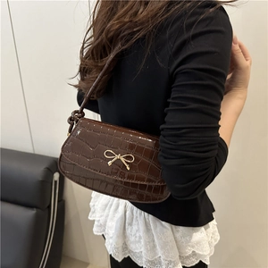 Stylish dark brown crocodile pattern crossbody bag with a golden bow and knot strap