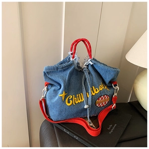Detail of embroidered Chill Vibe lettering on a denim tote bag with red strap