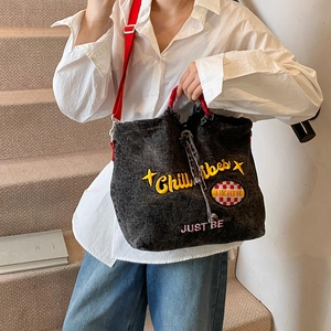 Chill vibes embroidered denim bucket bag with red handles and adjustable shoulder strap