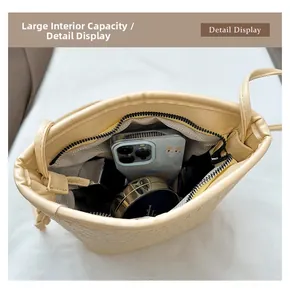 Detail view of the spacious interior of the woven bucket bag holding a phone and cosmetics