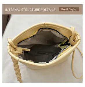Detail display of small bucket bag showing zipper closure and herringbone fabric lining
