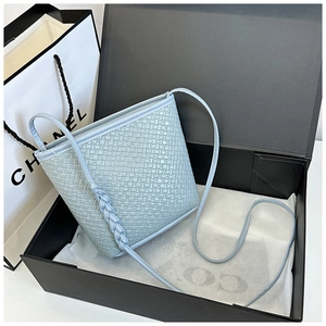 Close-up of light blue woven bucket bag showing intricate cross-weave texture and detail