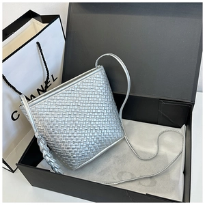 Detailed close-up of a silver woven bucket bag with intricate leather craftsmanship