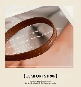 Detailed close-up of brown leather shoulder strap with reinforced double stitching detail