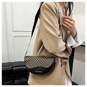 Detail view of the vintage leopard print texture and golden text on a crossbody saddle bag