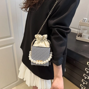Mini woven bucket bag with pearl handle and golden chain strap for stylish women