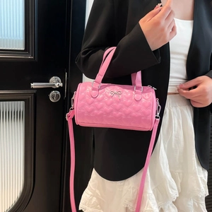 Bolso cilíndrico rosa acolchado con lazo plateado y correa desmontable
