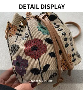 Detail of woven bucket bag with floral jacquard pattern and brown leather drawstring