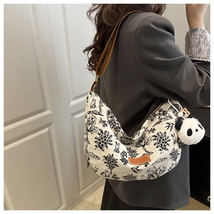 Classic half-moon canvas tote with black print and panda plush charm detail