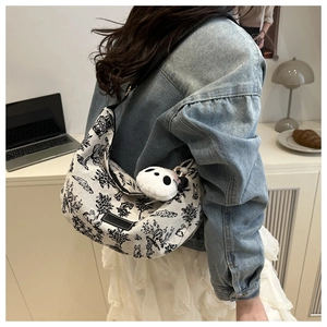 Lifestyle view of canvas hobo bag with bunny prints and plush panda charm detail