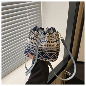 Dettaglio della borsa a secchiello intrecciata blu e bianca con coulisse celeste fine