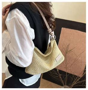 Close-up of beige woven shoulder bag featuring premium texture and leather strap detail