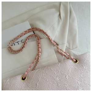 Detail of pink floral embossed fabric bag with golden chain strap and white embroidery