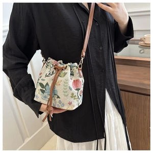 Dettaglio borsa a secchiello jacquard floreale con coulisse marrone sulla modella