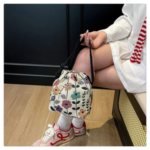 Detail shot of jacquard bucket bag with floral embroidery and drawstring closure