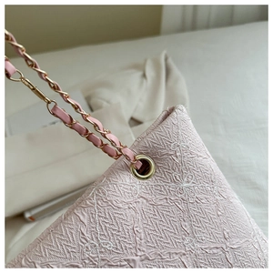 Close-up of pink jacquard fabric tote with floral embroidery and golden chain strap