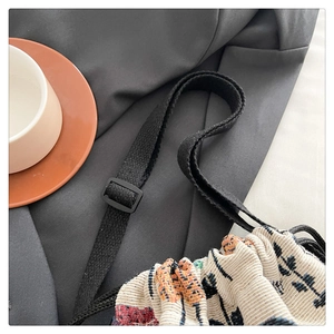 Close-up of ethnic jacquard woven shoulder bag with adjustable strap and drawstring detail