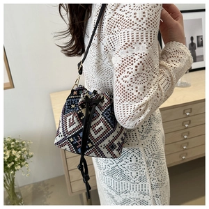 Borsa a secchiello etnica intrecciata con motivi geometrici e coulisse in pelle nera