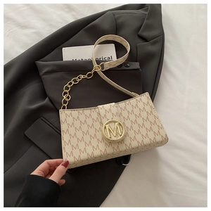 Detail of beige letter print underarm bag with gold M-logo buckle and chain strap