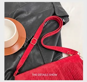 Detail showing the adjustable golden metal buckle and red suede tassel bag strap