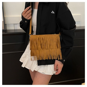 Détail du sac bandoulière bohème en daim marron avec de longues franges et style rétro