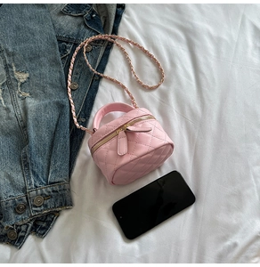 Detailed macro view of pink quilted PU leather bag with golden double zipper closure
