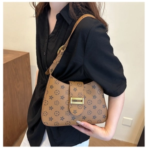 Detail of trendy brown crossbody bag with vintage star pattern and gold buckle