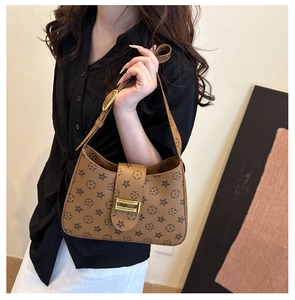 Dettaglio di una borsa hobo marrone a stelle con fibbia dorata e tracolla in pelle