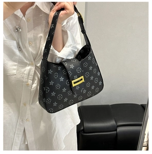 Vista laterale della borsa nera con motivi a stelle e fiori e chiusura in metallo dorato