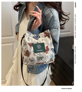 Detail of canvas tote bag with butterfly embroidery and green leather label tag