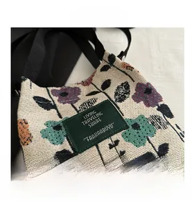 Detail of floral canvas bucket bag showing fabric texture and green logo patch