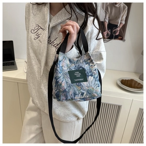 Detail of floral jacquard fabric on a stylish bucket bag with Living Traveling Share label