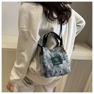 Detailed texture of floral jacquard tote bag with woven label and black handle