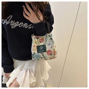Detail of floral tapestry tote bag featuring woven texture and Living Traveling Share label