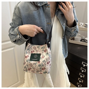 Detail shot of canvas tote bag with floral pattern shown on a denim jacket outfit