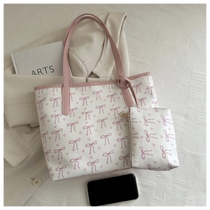 Detail view of floral tote bag with matching inner pouch on minimalist fabric