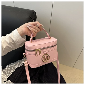 Dettaglio borsa a mano rosa con logo M dorato, doppia cerniera e tracolla sottile