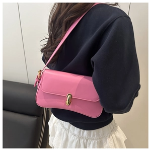 Detailed close-up of a pink leather underarm bag featuring a elegant gold metal buckle closure